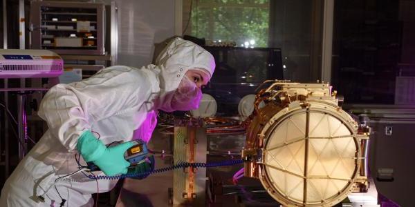 An engineer ground tests Europa Clipper’s dust analyzer.