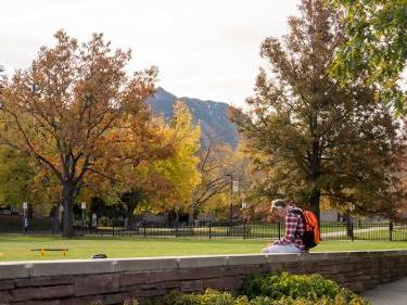 Student outside on CU Boulder campus in the Fall
