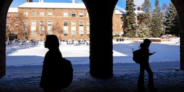 下雪天走在校园里的学生剪影